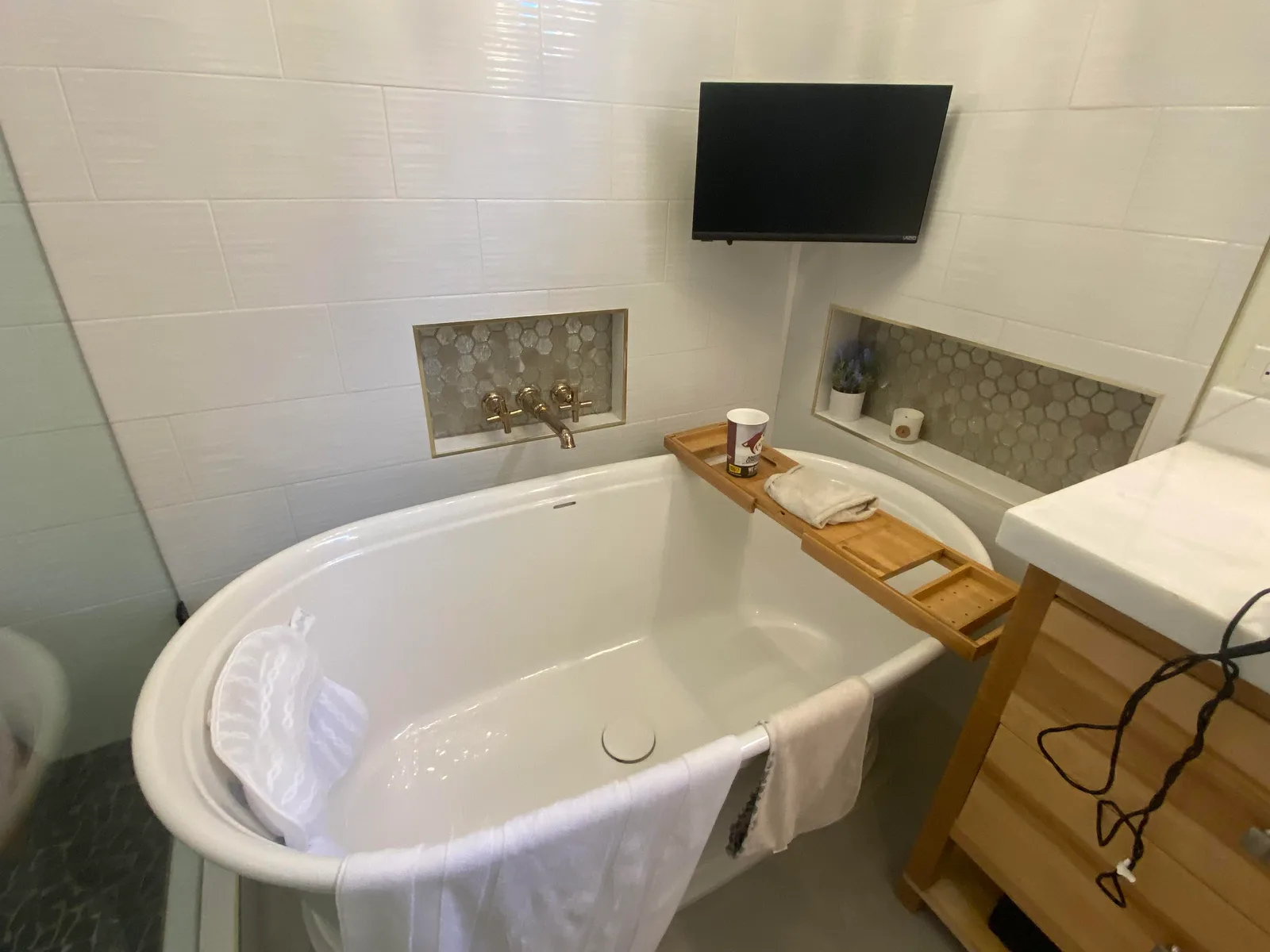 Spa-style bathroom remodel with freestanding soaking tub and tile niche