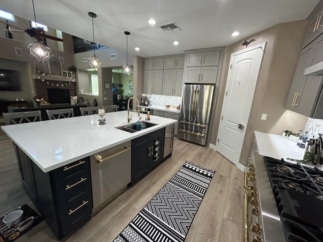 Custom kitchen remodel with quartz island, navy cabinetry, and brass hardware
